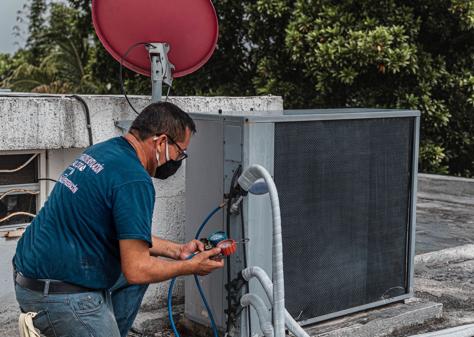 A technician servicing an outdoor air conditioning unit